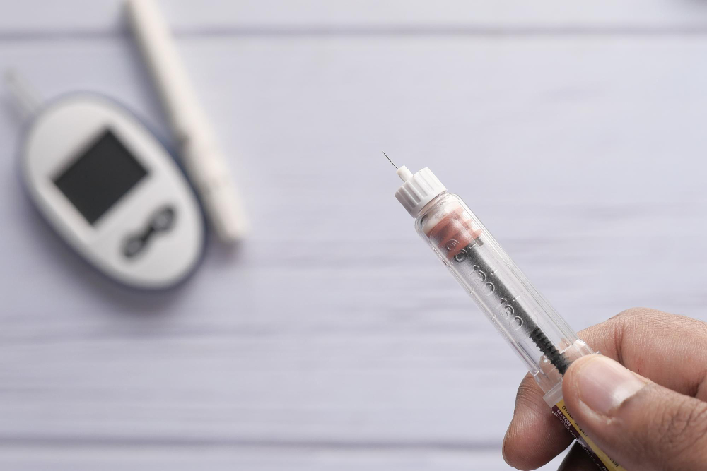 a hand holding a syringe focused on Insulin Needle